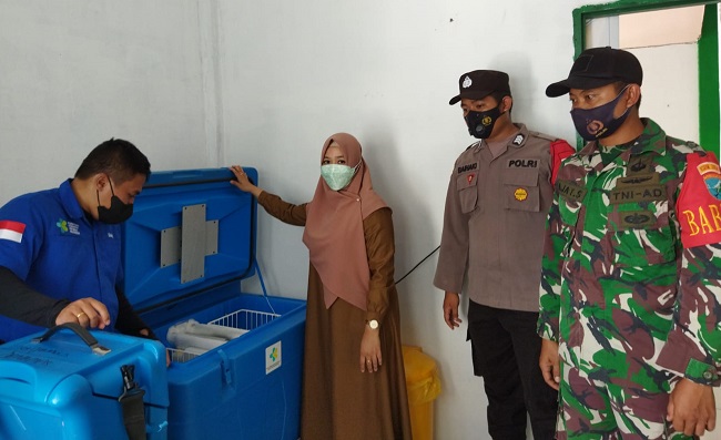 Anggota Babinsa Gelar Pengamanan Kedatangan Vaksin di Puskesmas Jenamas